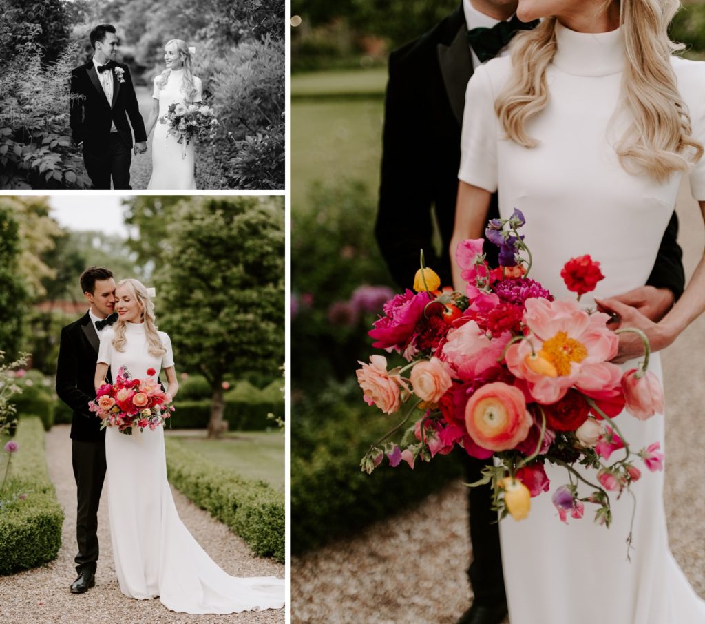 couple walking through gardens at West Green house gardens with colourful bridal bouquet