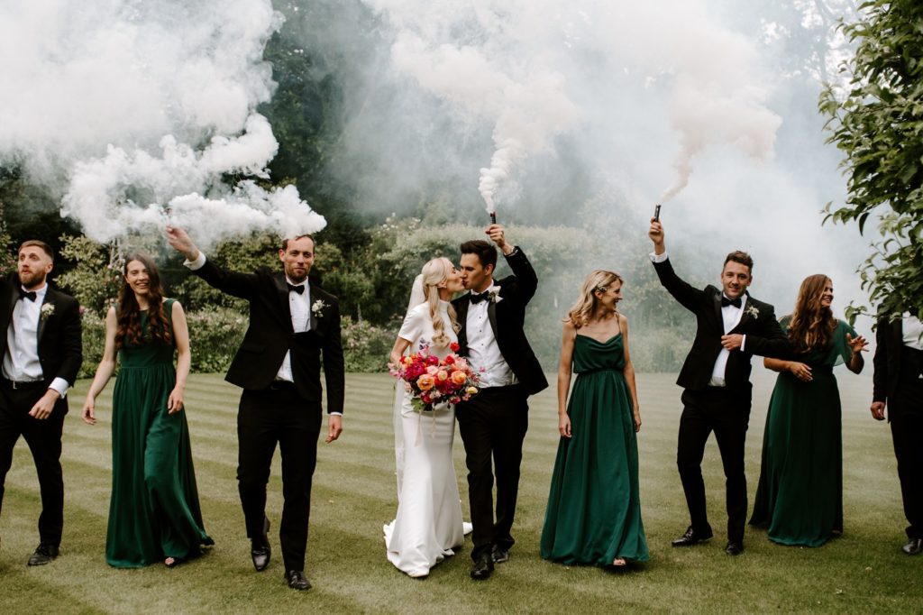 bridal party with smoke bombs at West Green house gardens