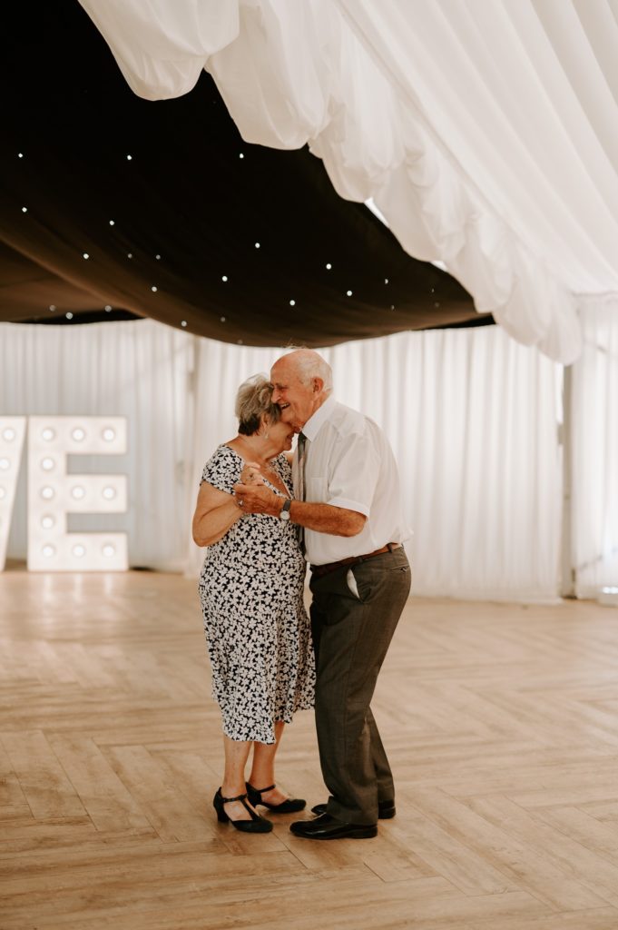 elderly couple dancing on dance floor 