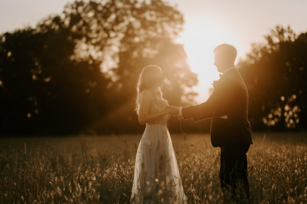 bride and groom at golden hour in a field