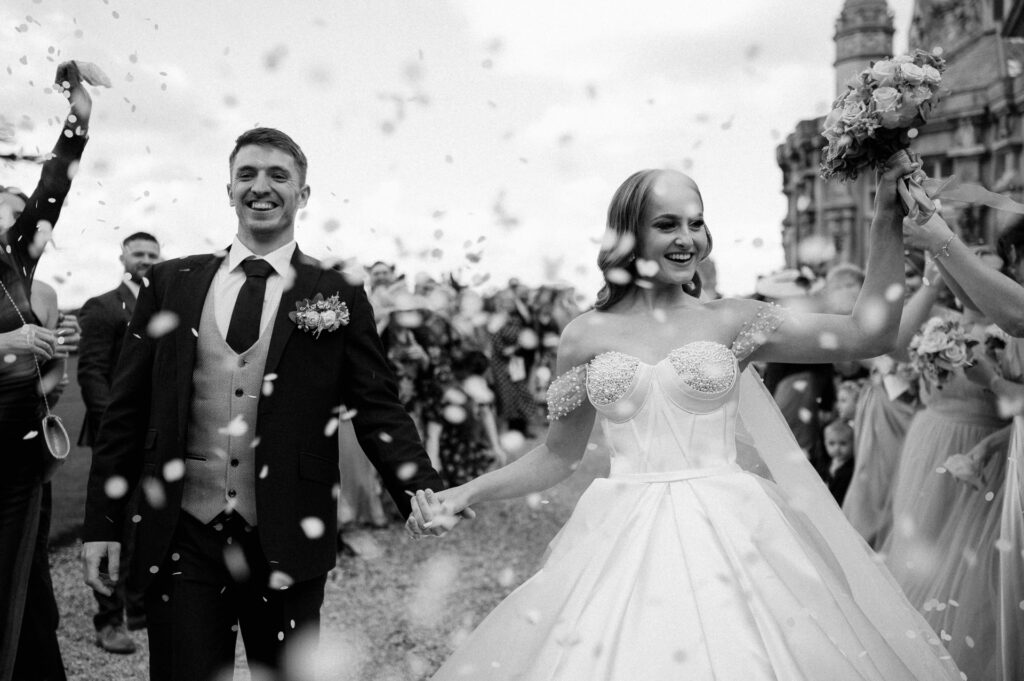 bride and groom at harlaxton manor with confetti