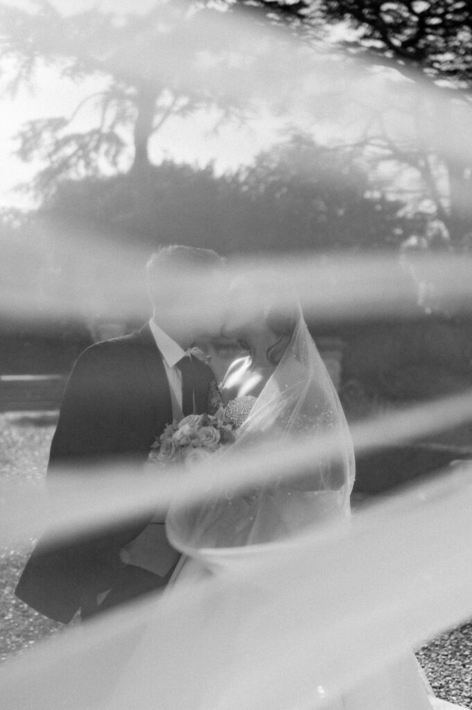 veil shot with couple kissing at harlaxton manor