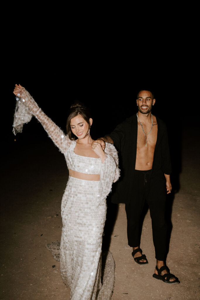 bride and groom dancing in desert at night