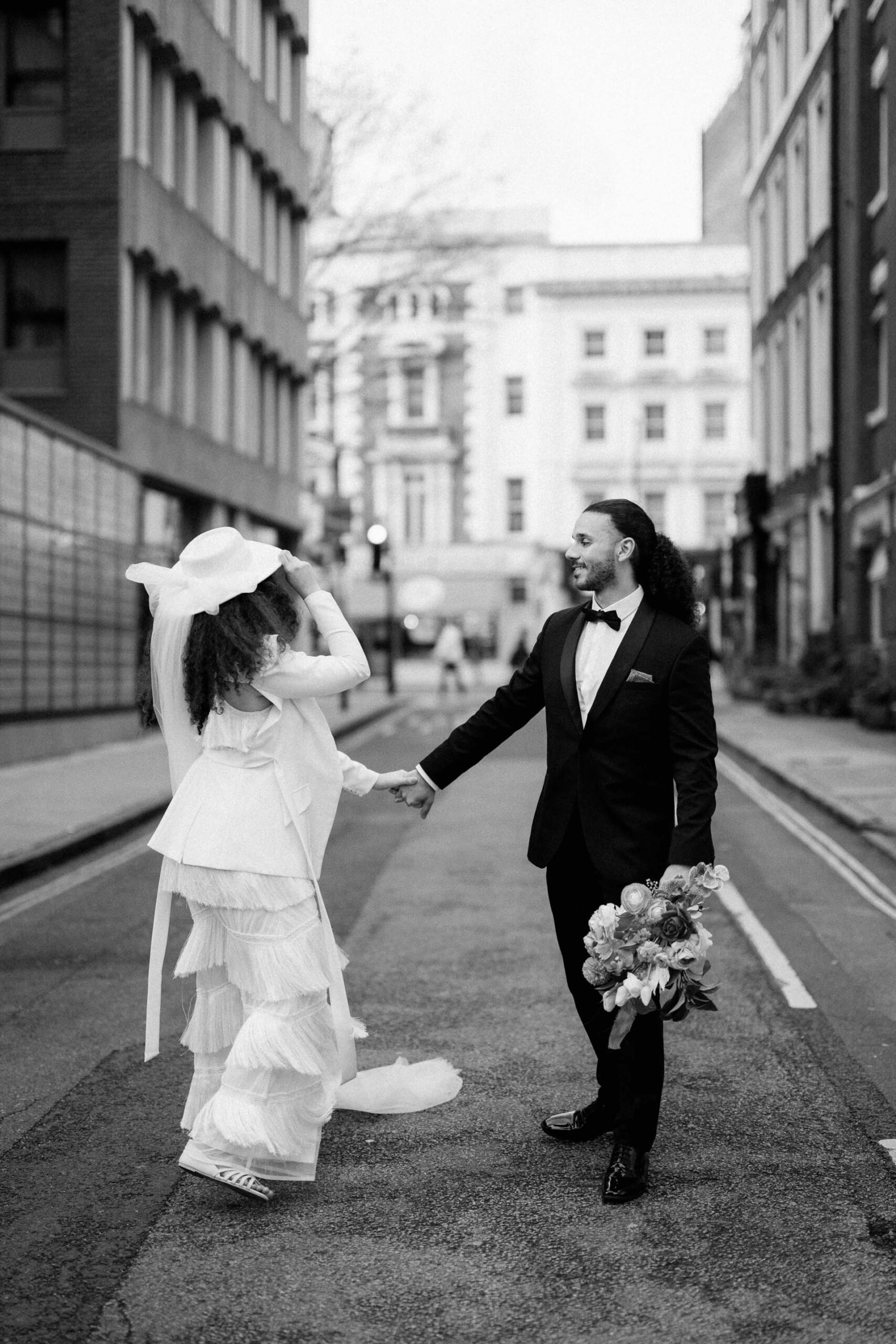 bride and groom walking down street in london