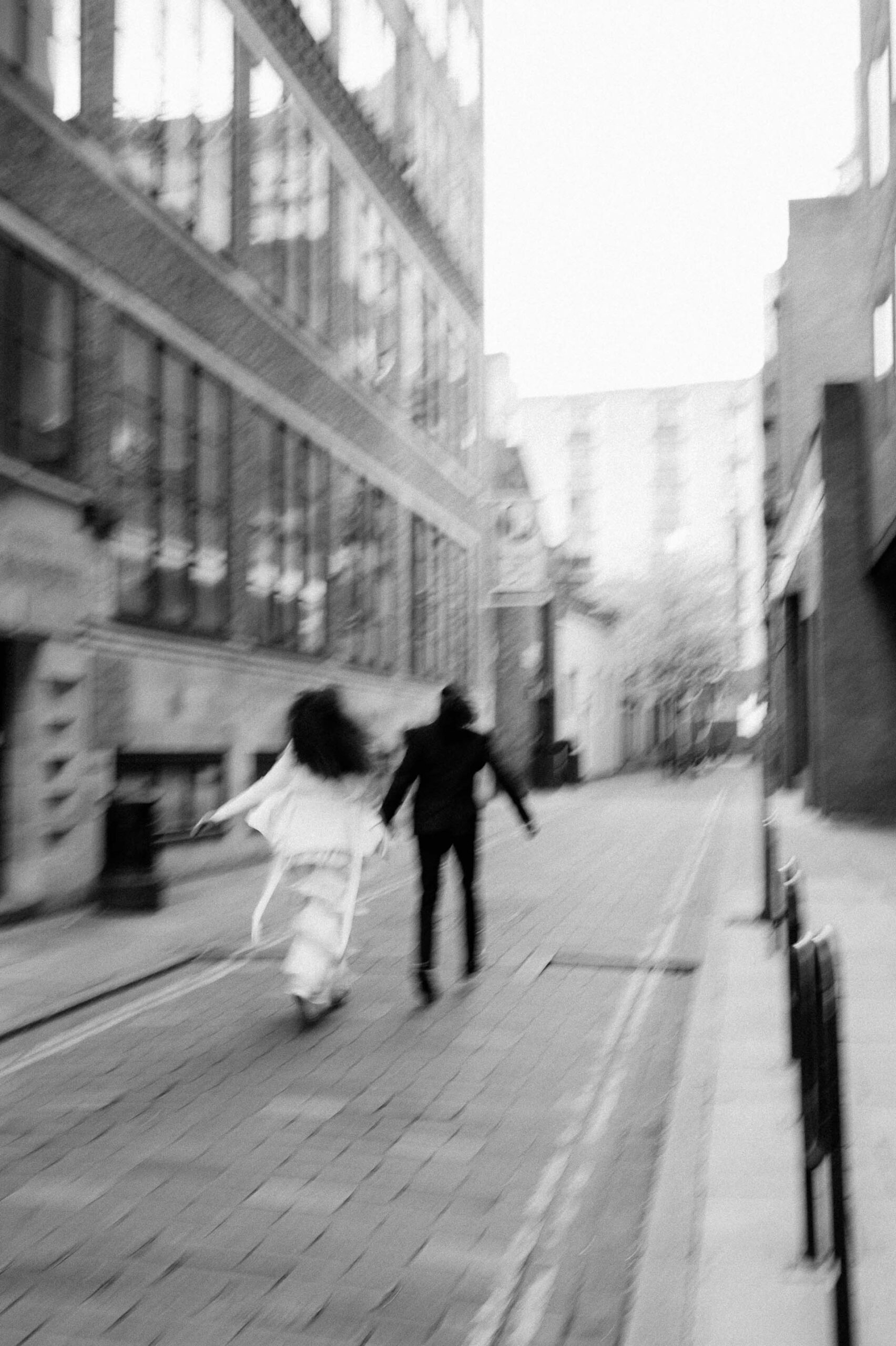 bride and groom running down streets of london