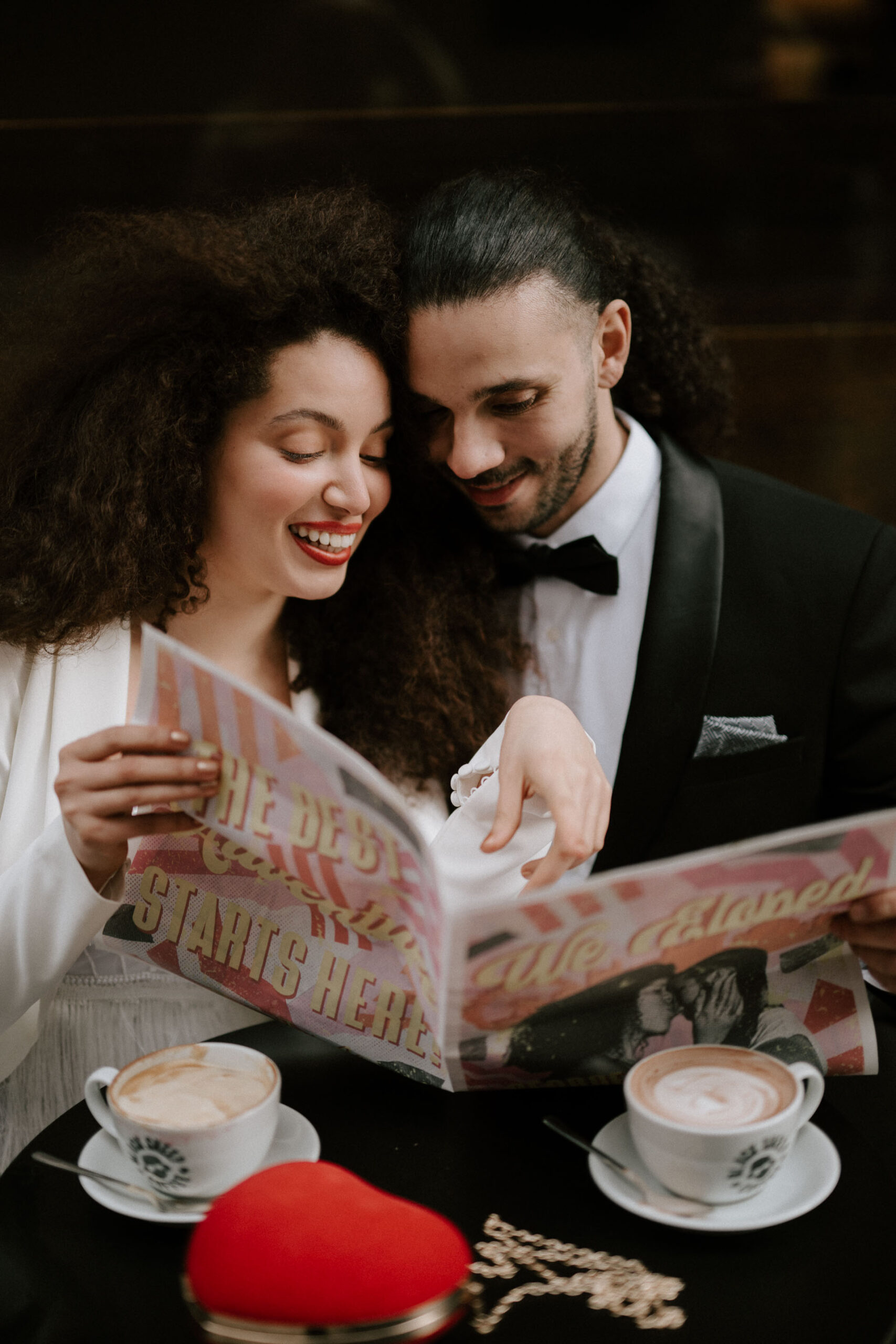 bride and groom at coffee shop drinking coffee reading newspaper