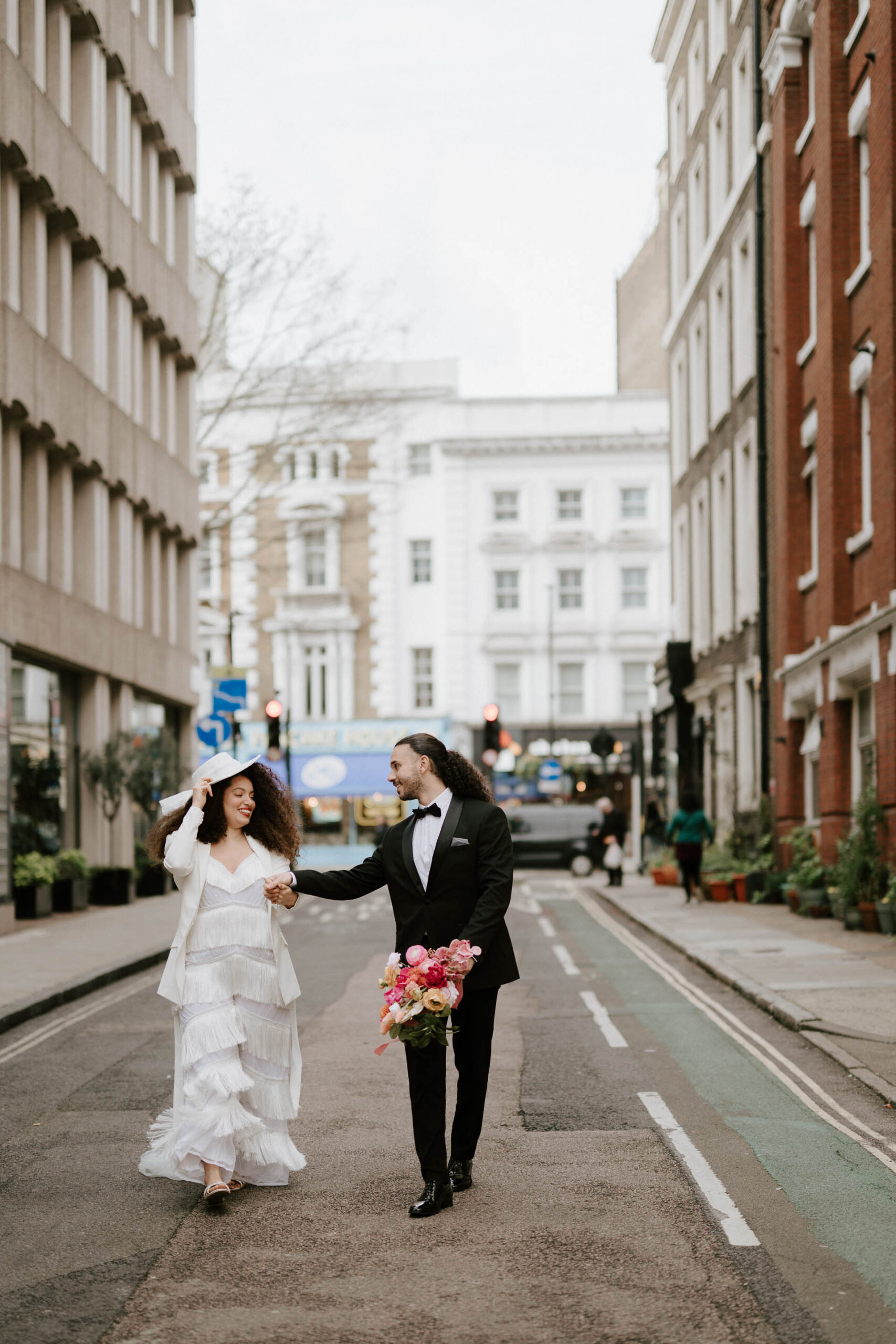 bride and groom walking down street in london