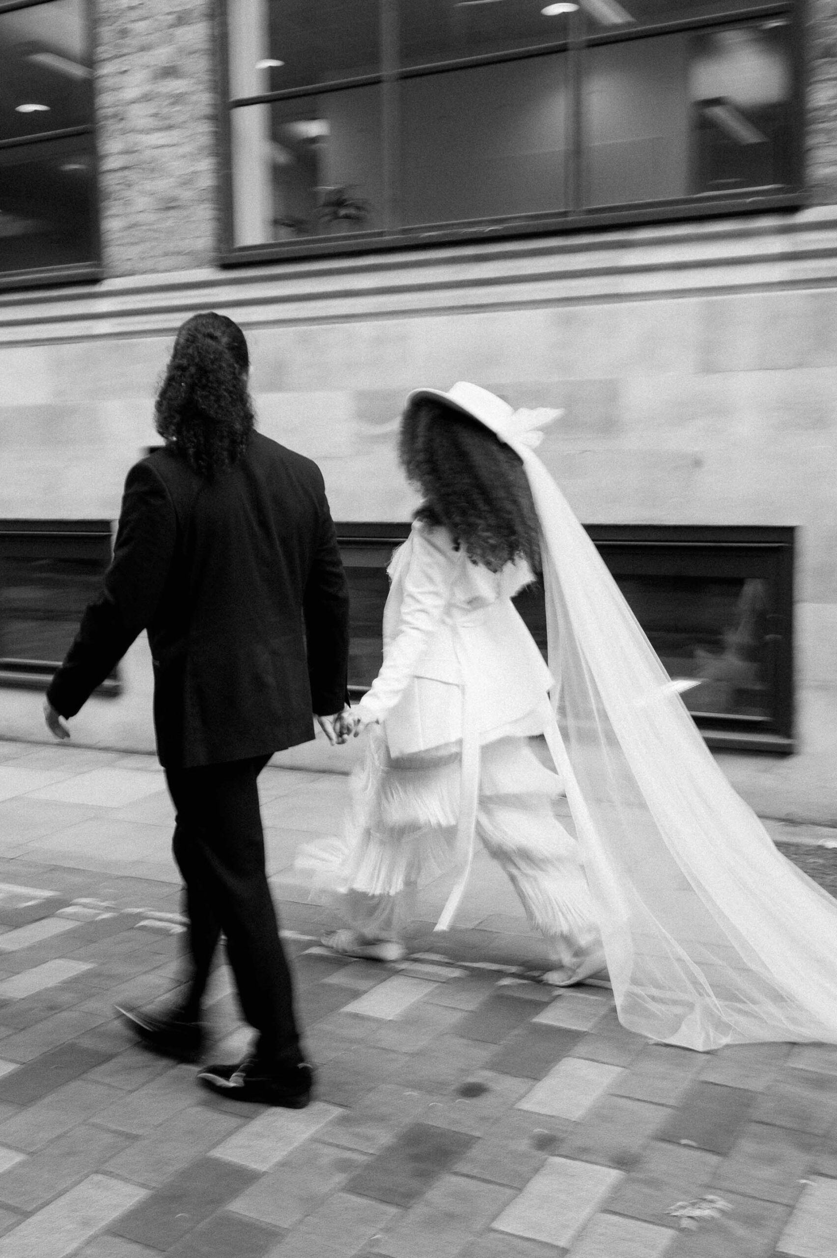 bride and groom walking down street in London with motion blur