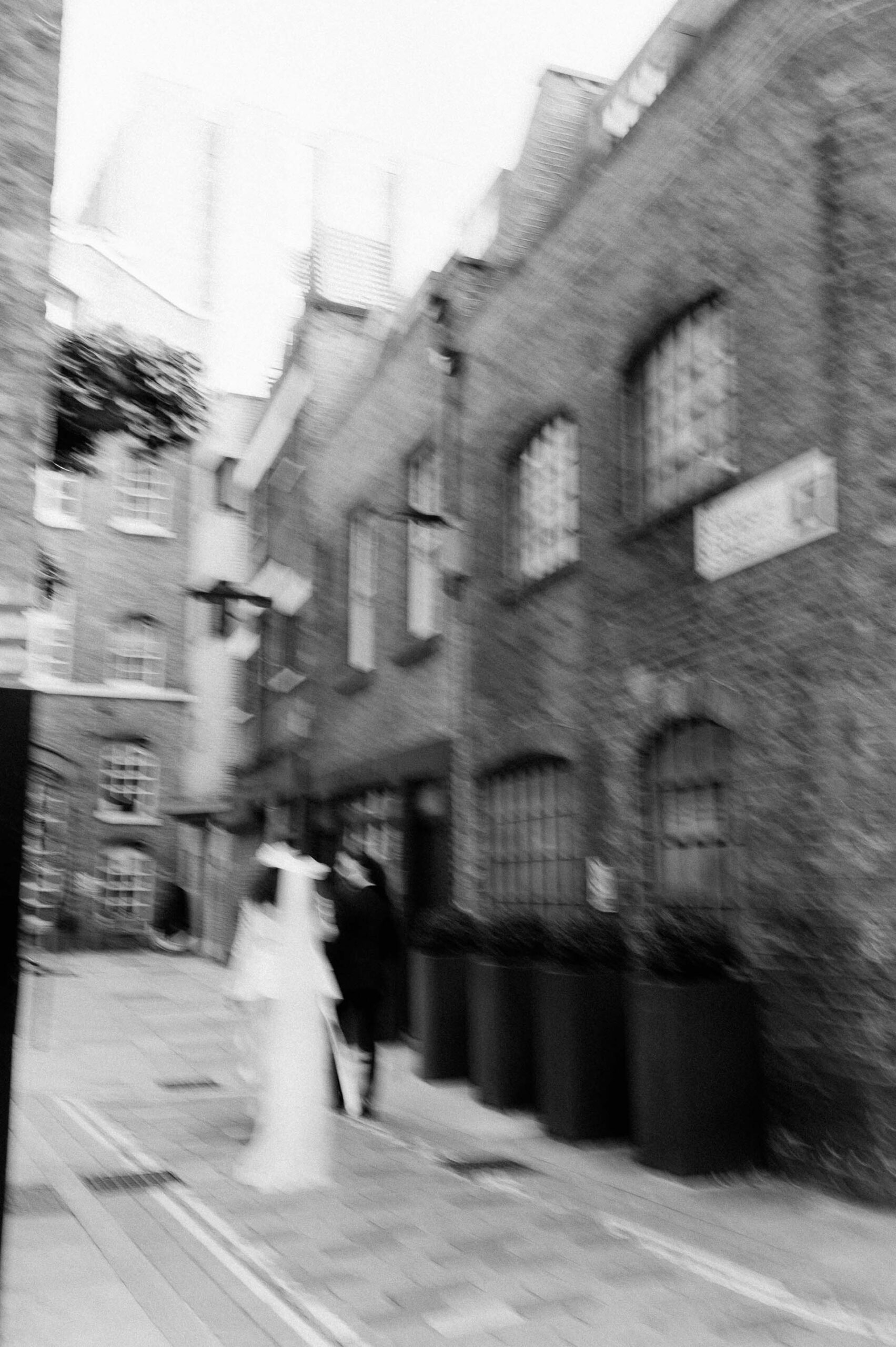 bride and groom walking down street in London with motion blur