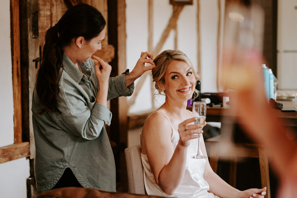 bride getting hair done on wedding morning at retreat east