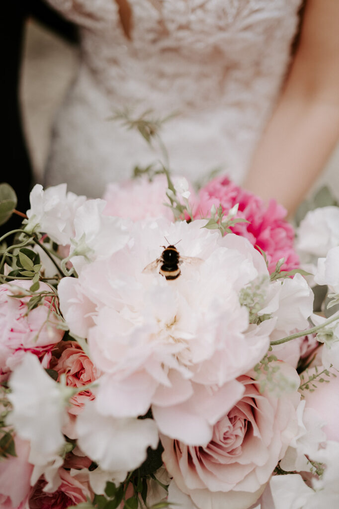 bee on pink peony bridal bouquet at retreat east