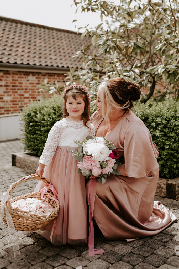 bridesmaid and flower girl holding confetti basket at retreat east