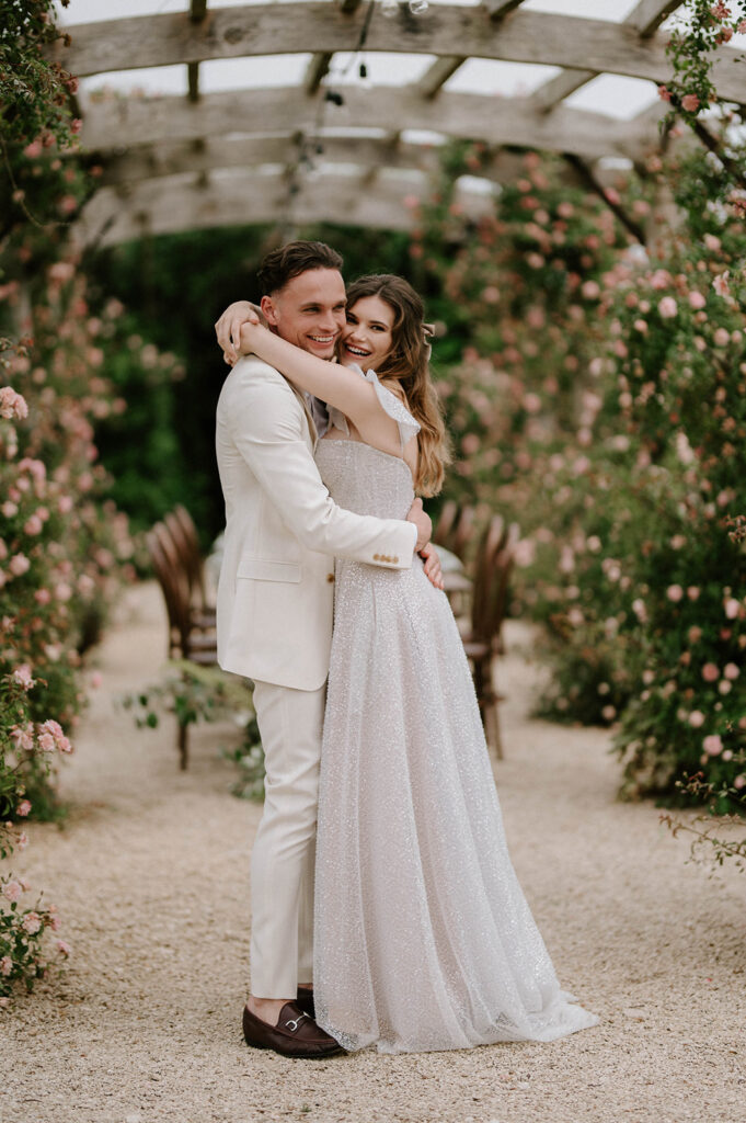 couple hugging at euridge manor in rose garden