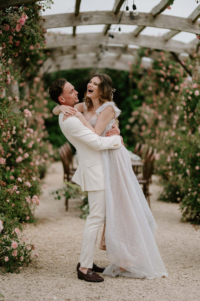 couple hugging at euridge manor in rose garden