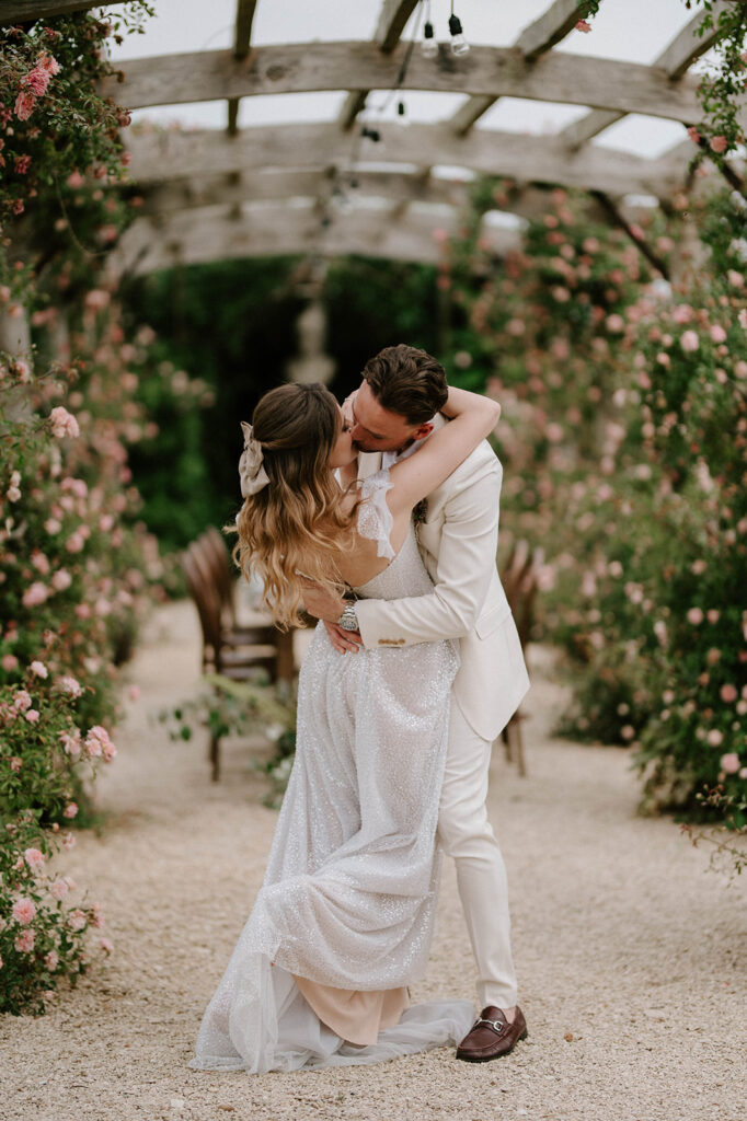 couple kissing at euridge manor in rose garden