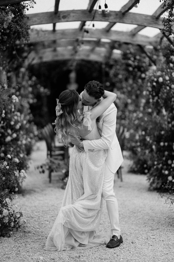 couple kissing at euridge manor in rose garden