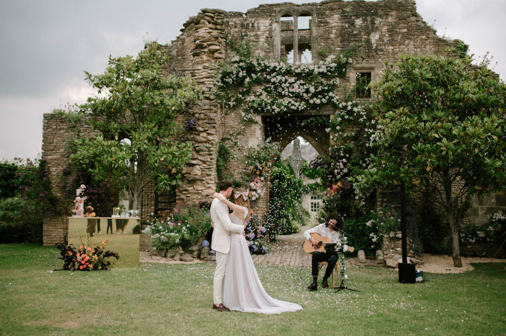 bride and groom having first dance outside in garden at euridge manor with confetti