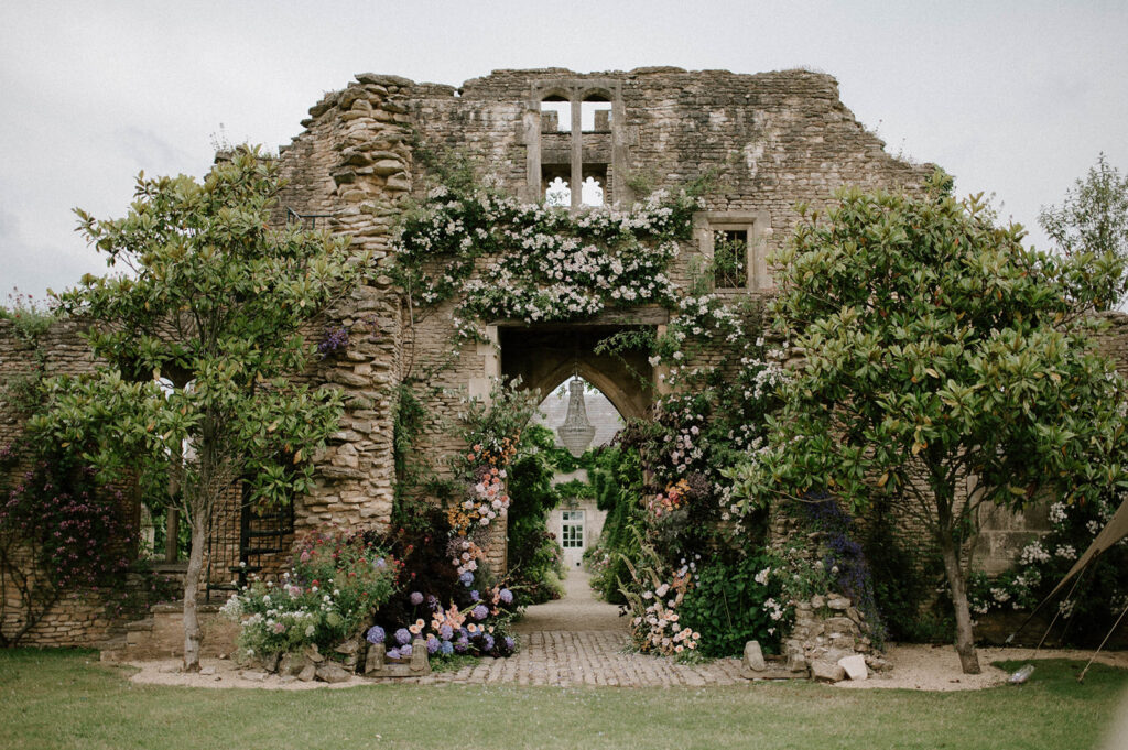 floral arch in ancient ruins at Euridge Manor cotswolds wedding venue