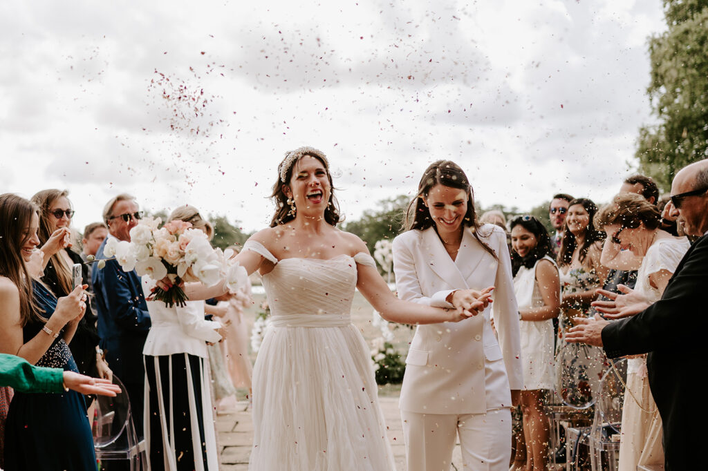two brides walking back down aisle with confetti
