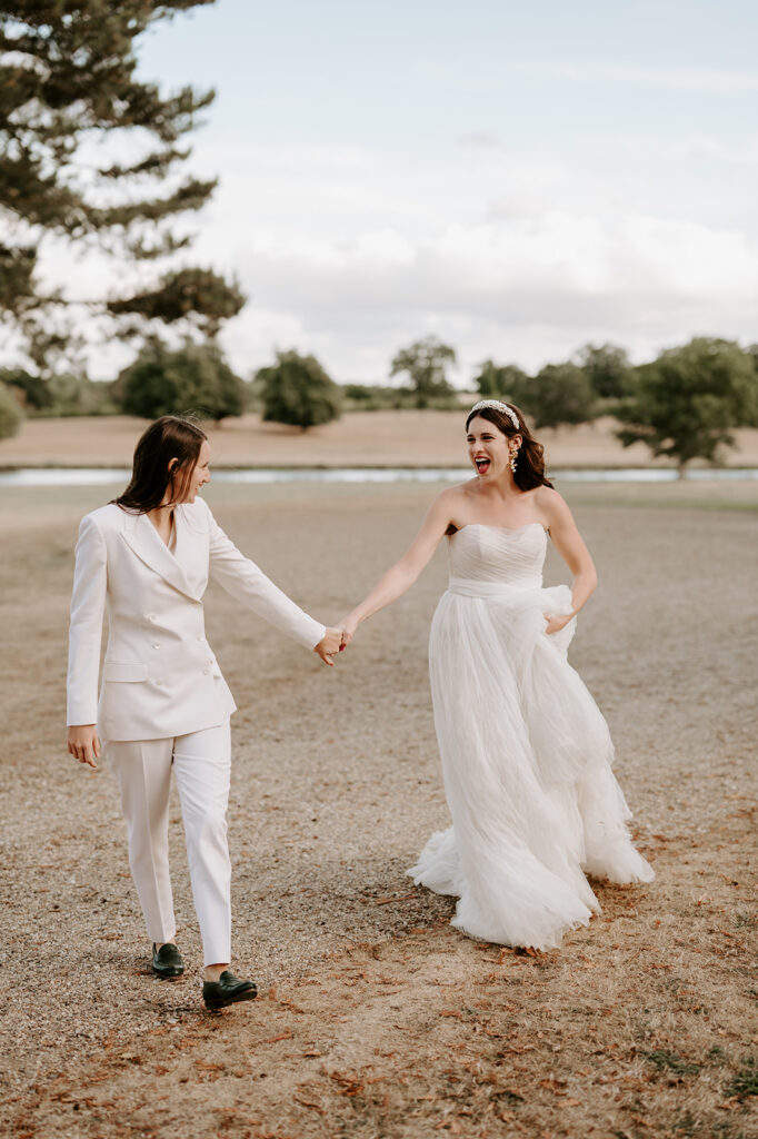 brides walking with lake in background