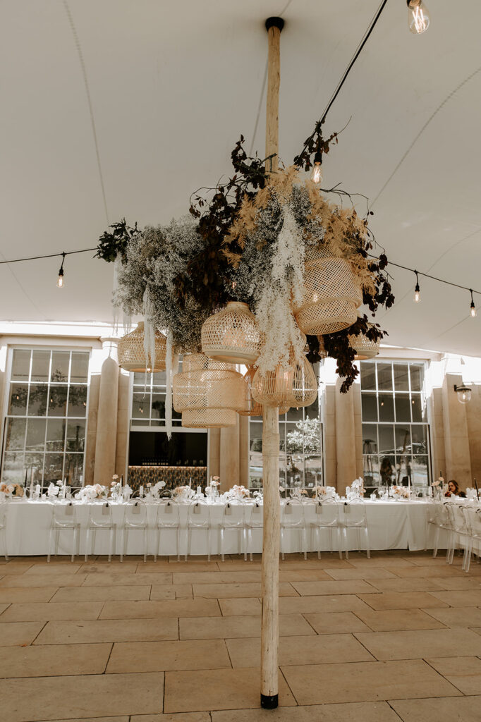 large neutral dried wedding flower display with lanterns in marquee at Sibton park