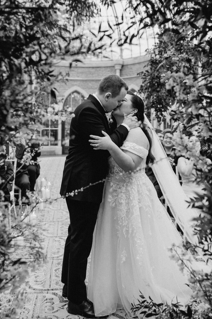 bride and groom sharing first kiss at tortworth court