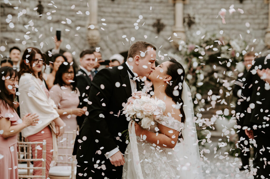 bride and groom kissing with white confetti 