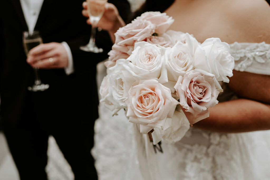 bride with champagne holding blush pink rose bridal bouquet 